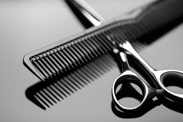 Friseurschere Und Haarbürste Nahaufnahme Auf Der Spiegelfläche Des Tisches — Stockfoto