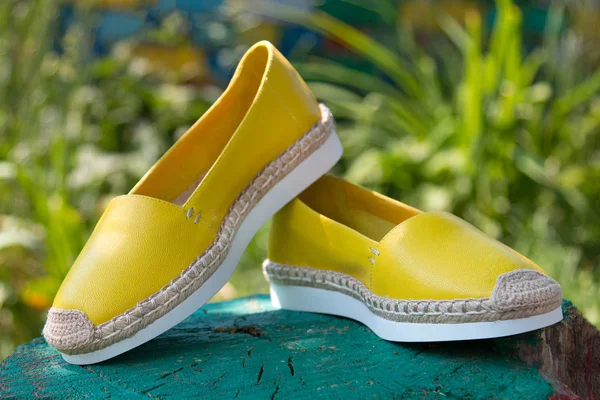Yellow espadrilles on a green background. — Stock Photo, Image