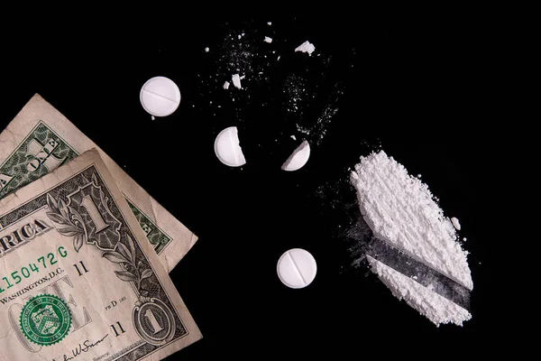 Money and drugs on a black background — Stock Photo, Image