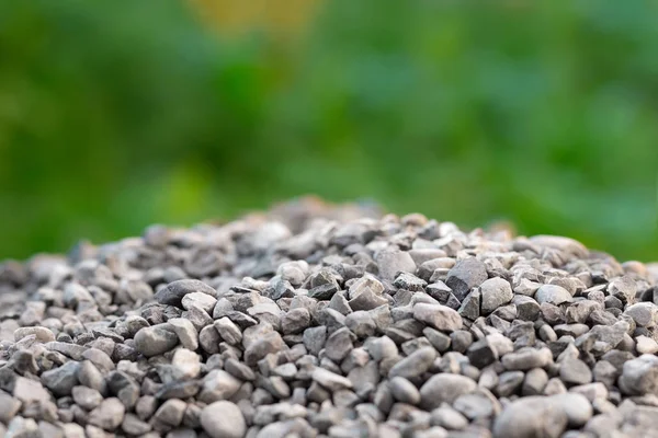 A pile of gravel stones against the backdrop of a green bokeh — Stock Photo, Image