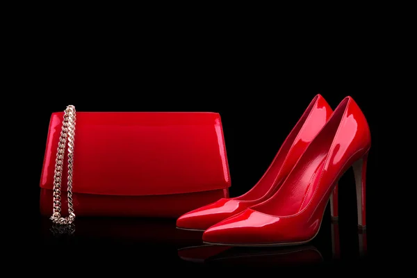 Red bag and red shoes on a black background