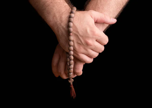 Hands of a male priest with a wooden rosary. — Stock Photo, Image