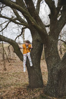 Sevimli kız eğleniyor ağacı üzerinde erken bahar 