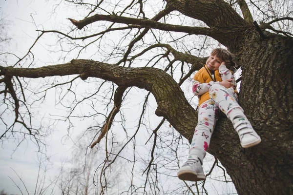 Sevimli kız eğleniyor ağacı üzerinde erken bahar 