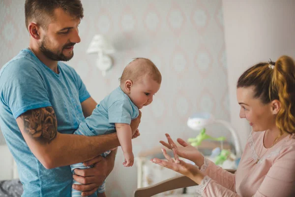 Evde bebekle mutlu genç ebeveynlerin portresi.