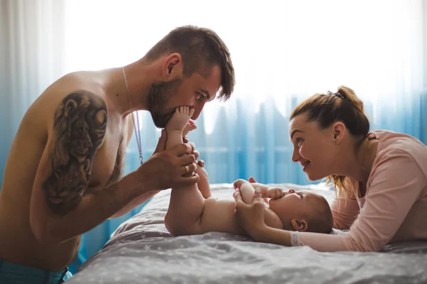 Evde bebekle mutlu genç ebeveynlerin portresi.