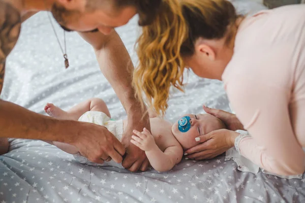 Bebek bezi bebek üzerinde koyarak mutlu anne portresi  