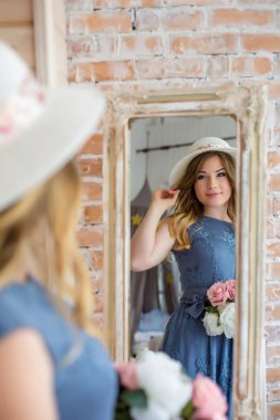 Güzel genç bayan aynaya bakıyor. 