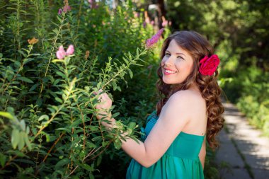 Güzel hamile kadın dışarıda poz veriyor.