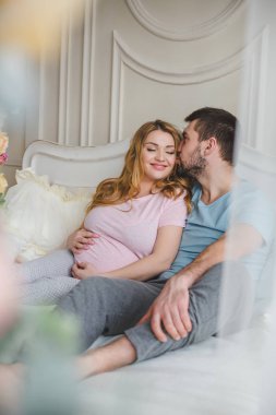 Genç ve mutlu bir aile. Kocasına hamile bir kadın.