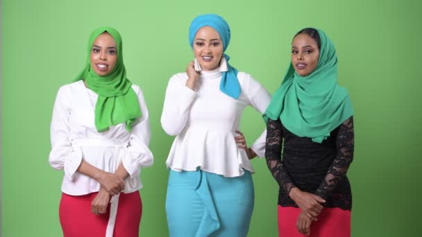 Drei junge afrikanische muslimische Frauen zusammen gegen Chromaschlüssel mit grünem Hintergrund — Stockvideo