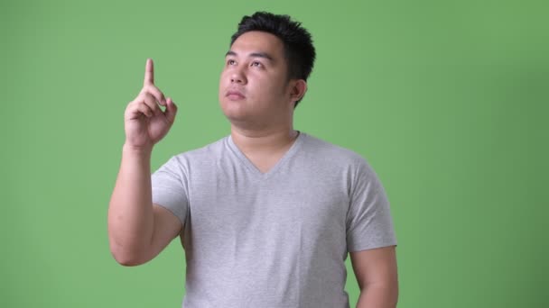 Jeune bel homme asiatique en surpoids sur fond vert — Video