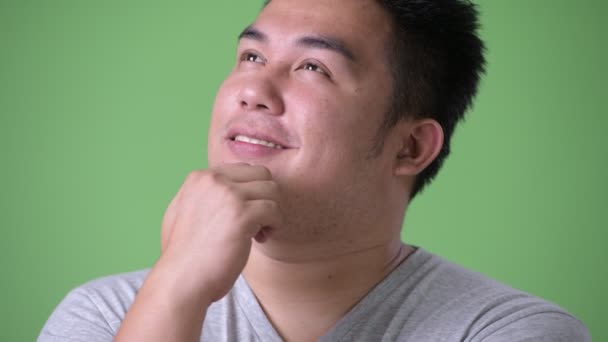 Giovane bello sovrappeso asiatico uomo contro verde sfondo — Video Stock