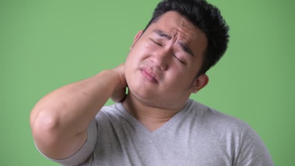 Young handsome overweight Asian man against green background — Stock Video