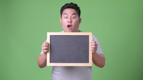 Mladý pohledný nadváha Asiat proti zeleným pozadím — Stock video