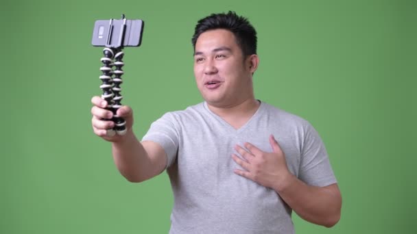 Joven guapo sobrepeso asiático hombre contra verde fondo — Vídeo de stock