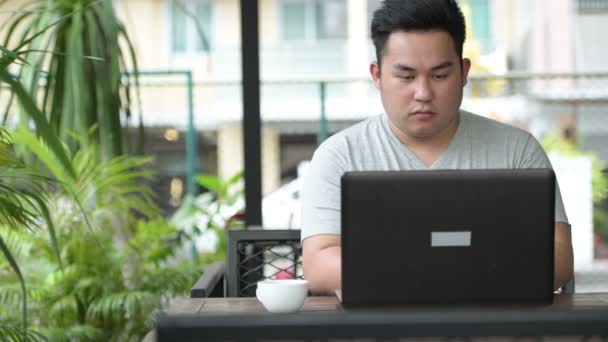 Jonge knappe overgewicht Aziatische man ontspannen bij de koffieshop — Stockvideo