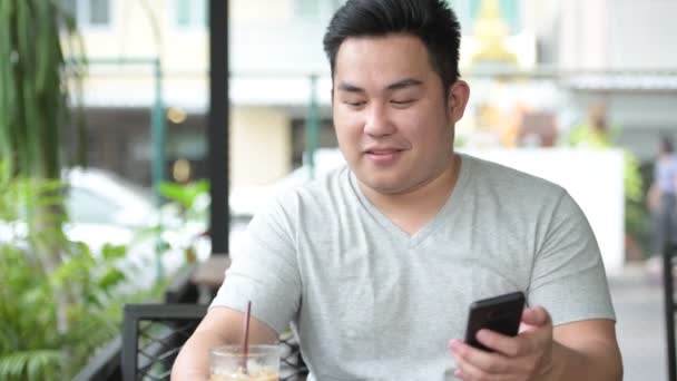 Joven guapo sobrepeso asiático hombre relajarse en la cafetería — Vídeo de stock