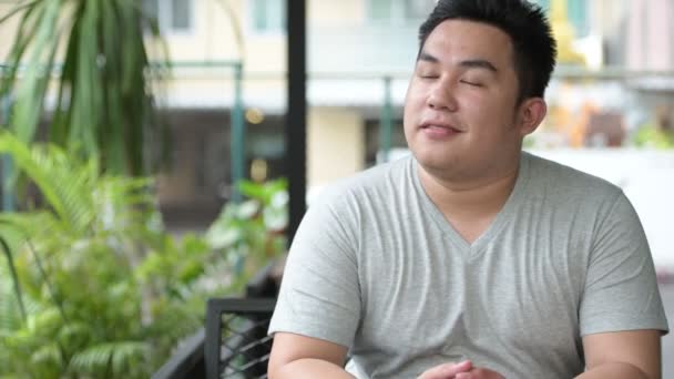 잘생긴 젊은 아시아 남자는 커피숍에서 편안한과 체중 — 비디오