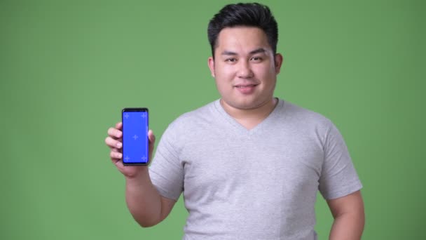 젊은 잘생긴 체중 녹색 배경 아시아 남자 — 비디오