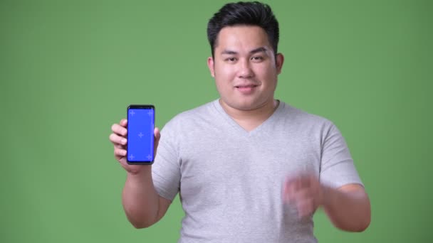 太りすぎの若いハンサムな緑の背景にアジア男 — ストック動画