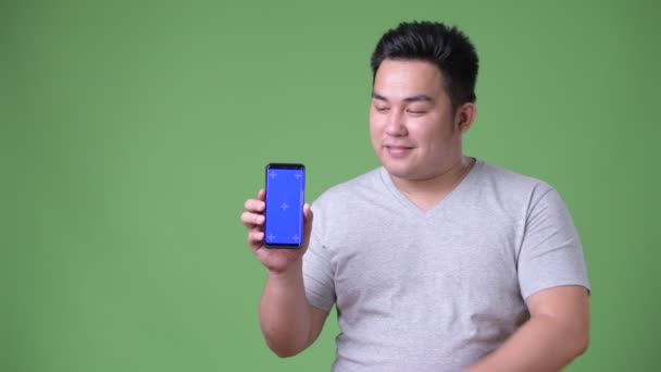 Jovem bonito acima do peso asiático homem contra fundo verde — Vídeo de Stock