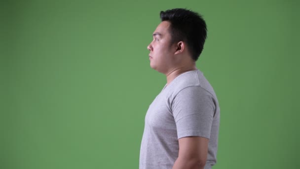 Jovem bonito acima do peso asiático homem contra fundo verde — Vídeo de Stock