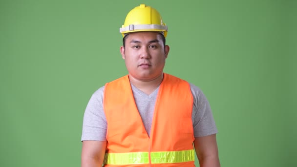 Joven guapo sobrepeso asiático hombre construcción trabajador contra verde fondo — Vídeos de Stock