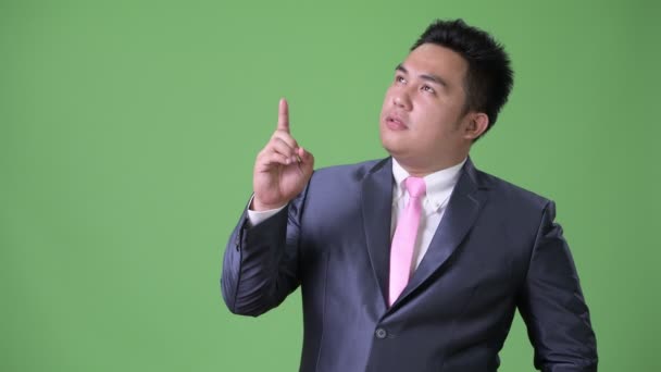 Jovem bonito sobrepeso asiático empresário contra fundo verde — Vídeo de Stock