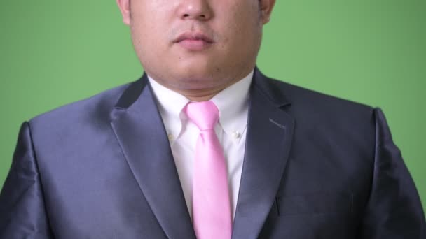 Young handsome overweight Asian businessman against green background — Stock Video