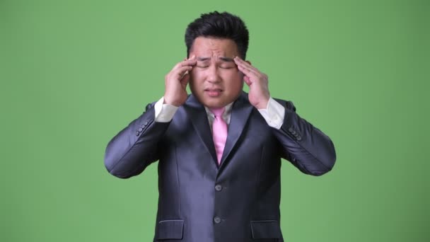 Young handsome overweight Asian businessman against green background — Stock Video