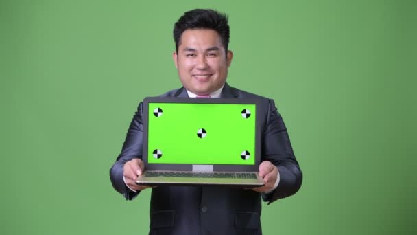Joven guapo sobrepeso asiático hombre de negocios contra fondo verde — Vídeo de stock