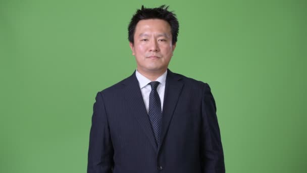 Mature homme d'affaires japonais sur fond vert — Video