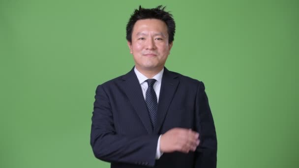 成熟的日本商人反对绿色背景 — 图库视频影像