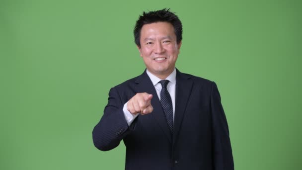 Starší japonský podnikatel proti zeleným pozadím — Stock video