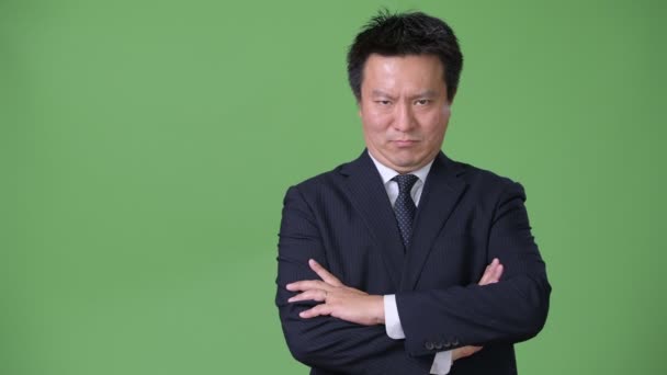 Зрелый японский бизнесмен на зеленом фоне — стоковое видео