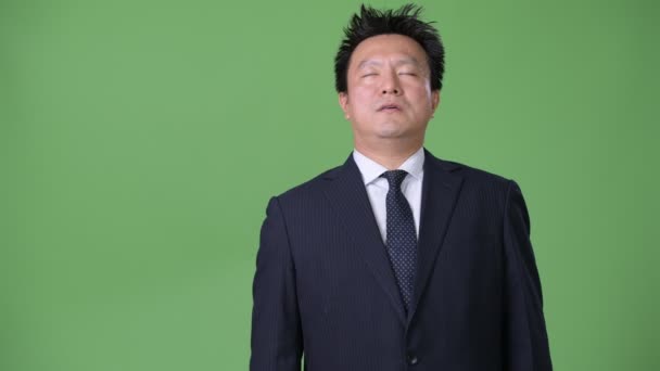 Japanischer Geschäftsmann vor grünem Hintergrund — Stockvideo