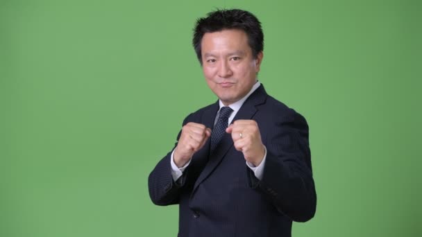 緑の背景に成熟した日本のビジネスマン — ストック動画