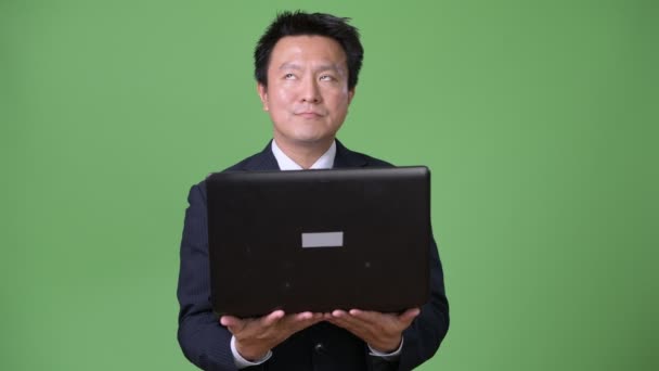 Olgun Japon işadamı yeşil bir arka plana dayanır — Stok video