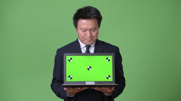 Mogna japansk affärsman mot grön bakgrund — Stockvideo