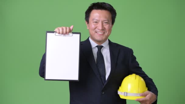 Зрілі японський бізнесмен на зеленому тлі — стокове відео