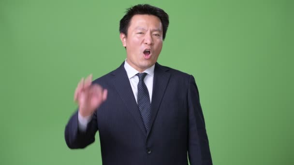 Mogna japansk affärsman mot grön bakgrund — Stockvideo