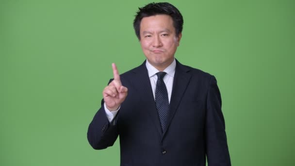 Starší japonský podnikatel proti zeleným pozadím — Stock video