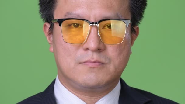 Maduro japonés hombre de negocios contra fondo verde — Vídeos de Stock