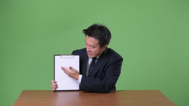 Dojrzały japoński biznesmen na zielonym tle — Wideo stockowe