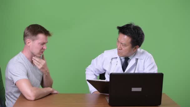Starší japonský muž lékař a mladý pacient s diskuse — Stock video