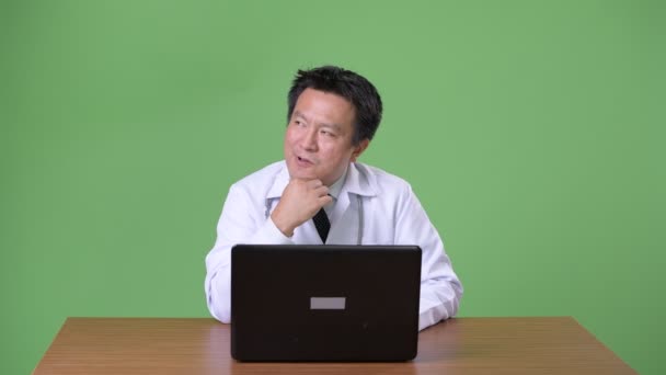 Starší japonský muž lékař proti zeleným pozadím — Stock video
