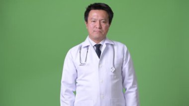 Olgun Japon adam doktor yeşil bir arka plana dayanır