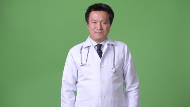 성숙한 일본 남자 의사 녹색 배경 — 비디오