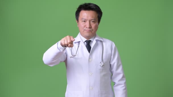 成熟的日本男性医生反对绿色背景 — 图库视频影像